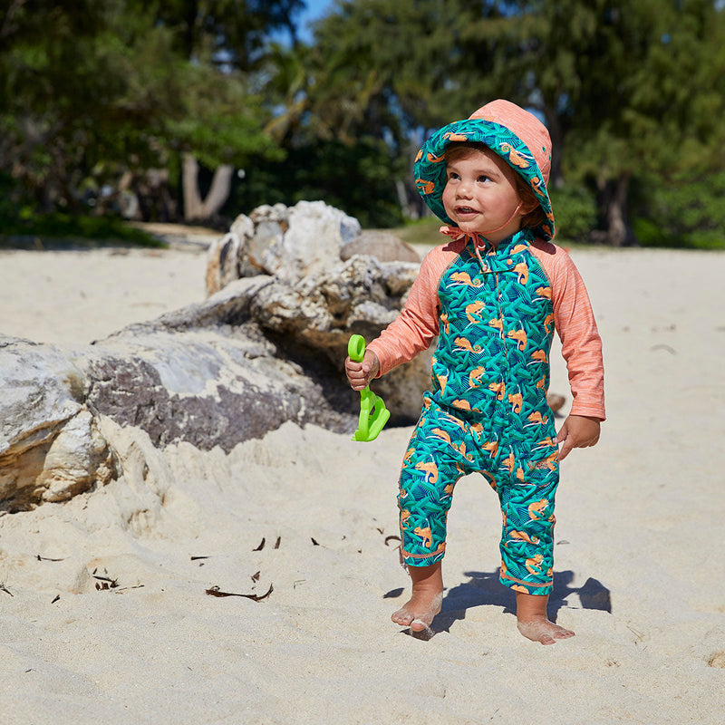 Baby boy on the beach wearing UV Skinz's baby boy's long-sleeve swimsuit in cool chameleons|cool-chameleons