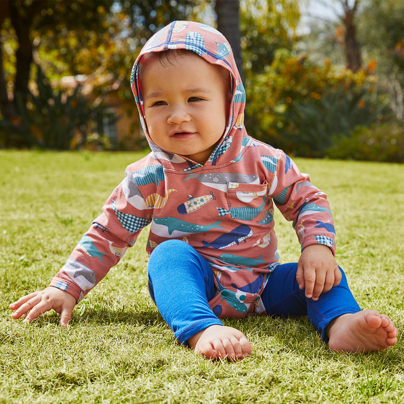 Baby in UV Skinz's hooded onesie in whale jumble|whale-jumble