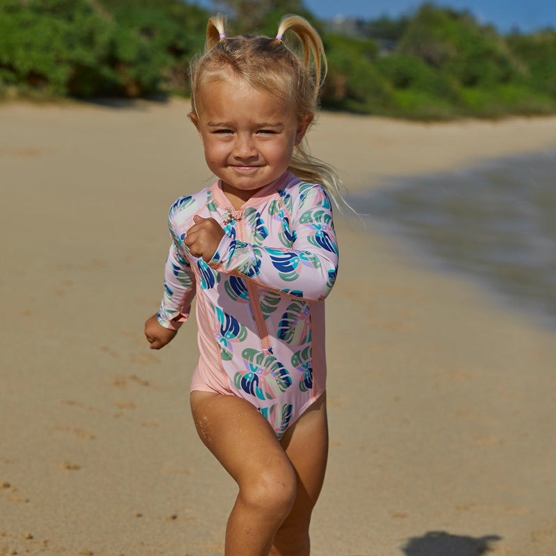 Baby girl in UV Skinz's girl's long sleeve swimsuit|lavender-fields