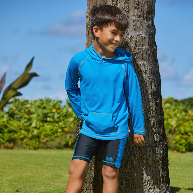 Boy wearing UV Skinz's boy's swim shorts in black royal|black-royal