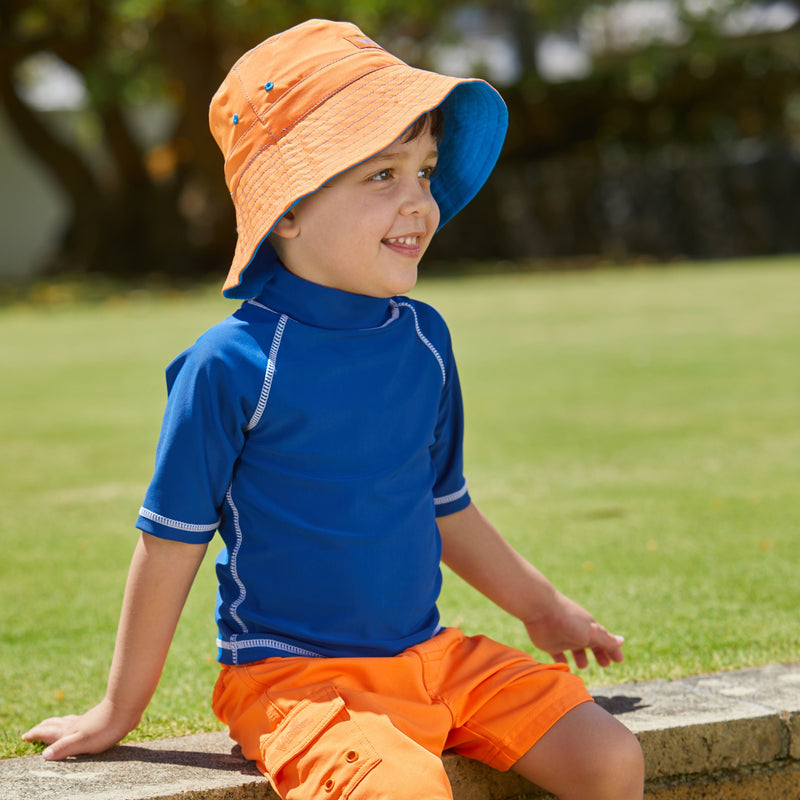 Young boy in UV Skinz's kid's short sleeve swim shirt in navy|navy