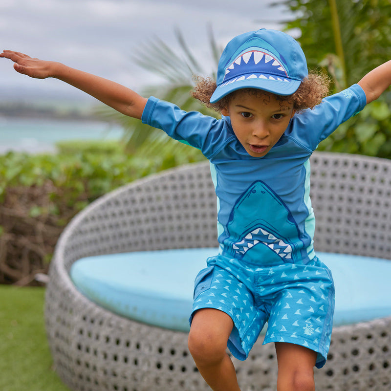 boy jumping in snap back hat|baltic-shark-bite