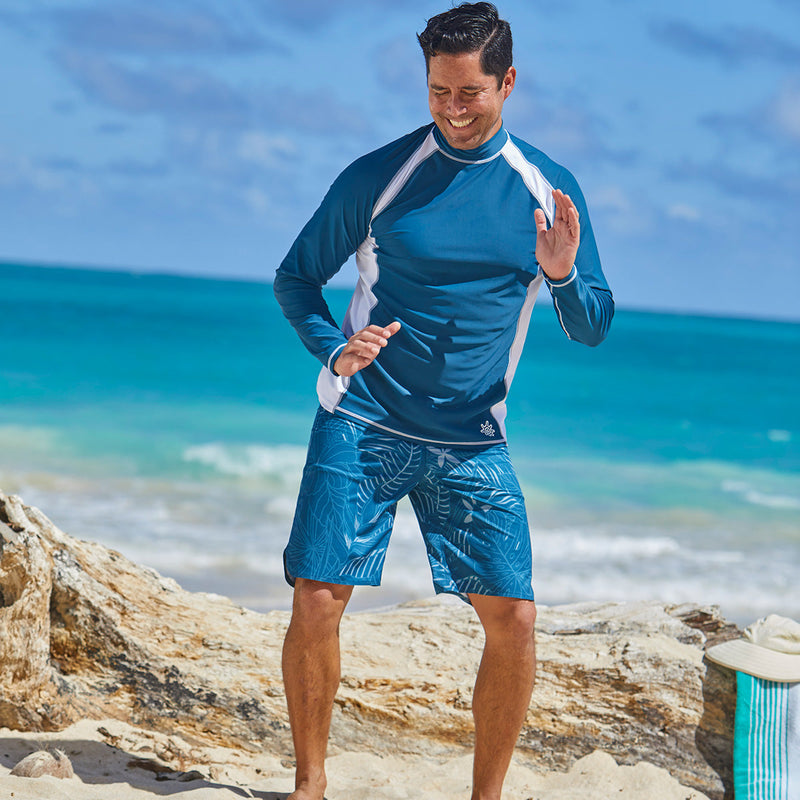 Man playing on the beach in UV Skinz's board shorts|midnight-oasis