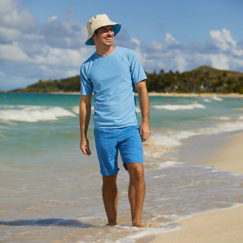 Man on the beach in UV Skinz's men's classic trunks in deep sea swirls|deep-sea-swirls