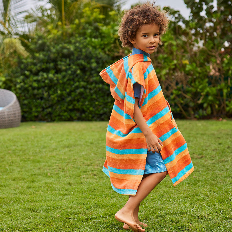 boy in kid's hooded beach poncho in sunset stripe|sunset-stripe