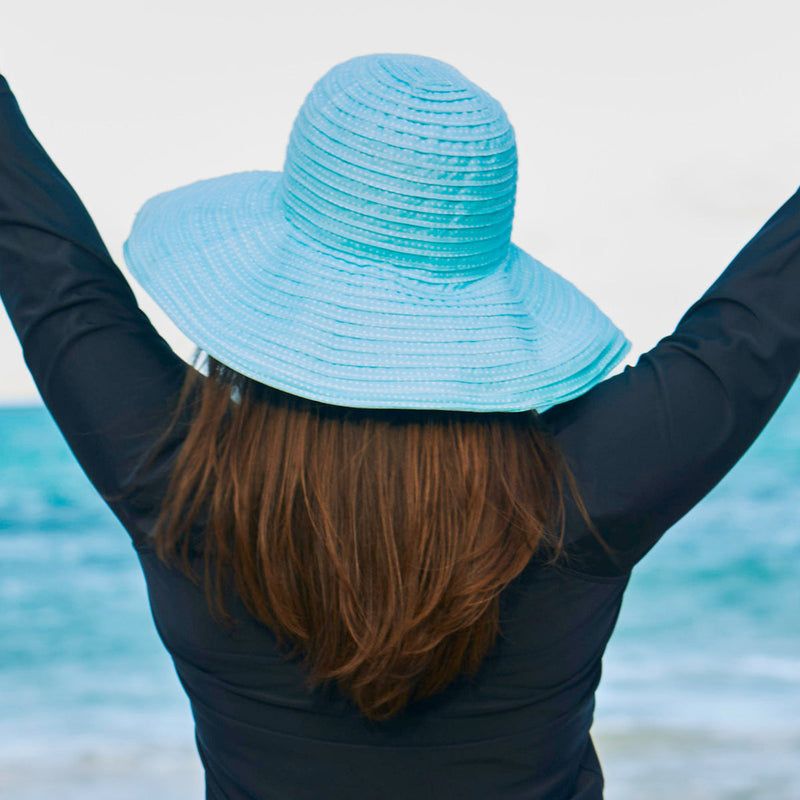 Woman in UV Skinz's wide brim sun hat|white