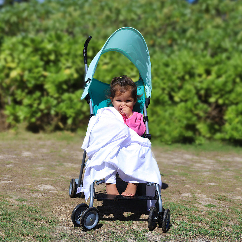 Little girl holding onto the My First Sun Blanket™ in White