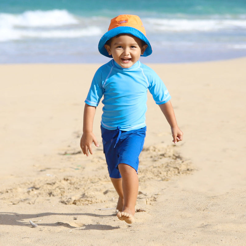 Boy on the Beach in UV Skinz's Boy's Classic Board Shorts in Navy|navy