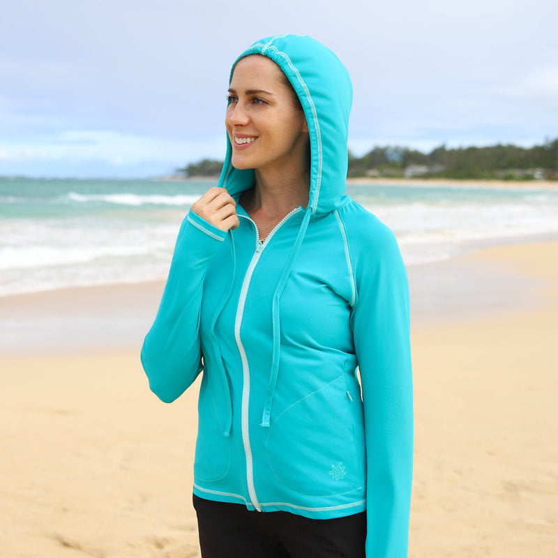 Woman in UV Skinz's women's hooded water jacket in teal|teal