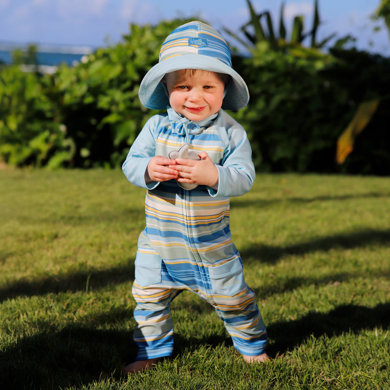 baby boy in grass in baby sun & swim suit in pinecrest stripe|pinecrest-stripe